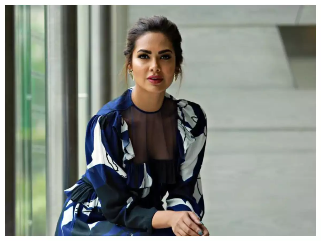 During her recent glamorous appearance, Esha Gupta donned a sultry sequined outfit that almost led to a wardrobe malfunction, revealing her busty assets. Netizens couldn't help but compare her to Indian Angelina Jolie. Read on to know more about her stunning green carpet look and the reactions it garnered on social media