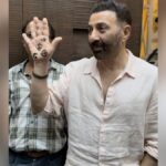 Bollywood actor-politician Sunny Deol steals the limelight with his distinctive mehendi design as he greets the paparazzi at his son Karan Deol's pre-wedding ceremony. Find out more about the henna-adorned hand and the upcoming wedding festivities.