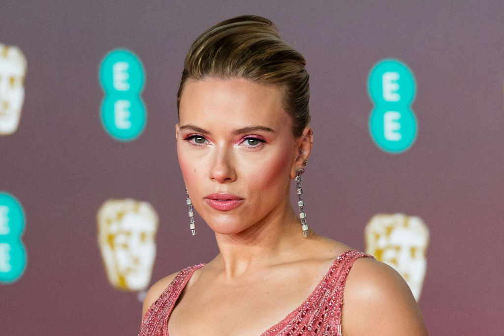 Scarlett Johansson's unique fashion sense and stunning beauty are on full display in a mesmerizing throwback photo. Wearing a bold sheer mesh ensemble, the actress proves she was born to portray Black Widow. Scroll ahead to check out the picture and read about her captivating style statements.