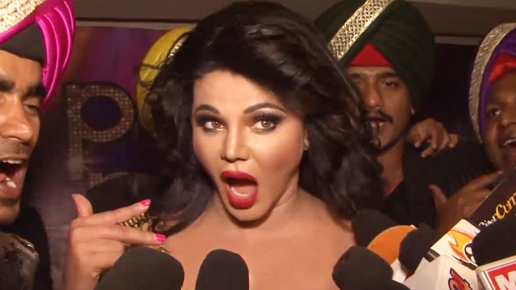 Rakhi Sawant, the entertainment queen, was recently seen at the airport dancing to the song 'What Jhumka?' in a green satin saree. However, her pallu kept falling, almost leading to a wardrobe malfunction. Netizens had their say, suggesting she use safety pins. Watch the video and read on for the full story!

